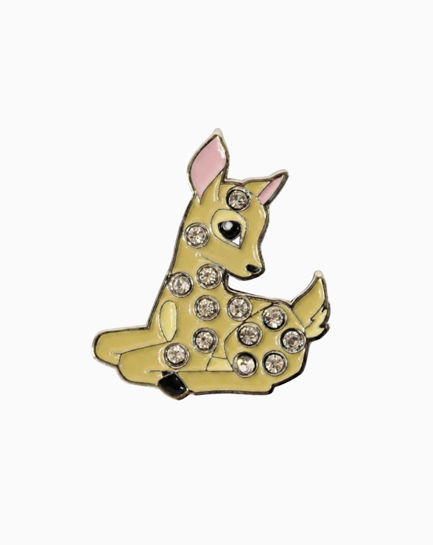 A round golf ball marker featuring a gold Bambi deer design adorned with Swarovski crystals, paired with a matching magnetic hat clip for elegant on-course style.