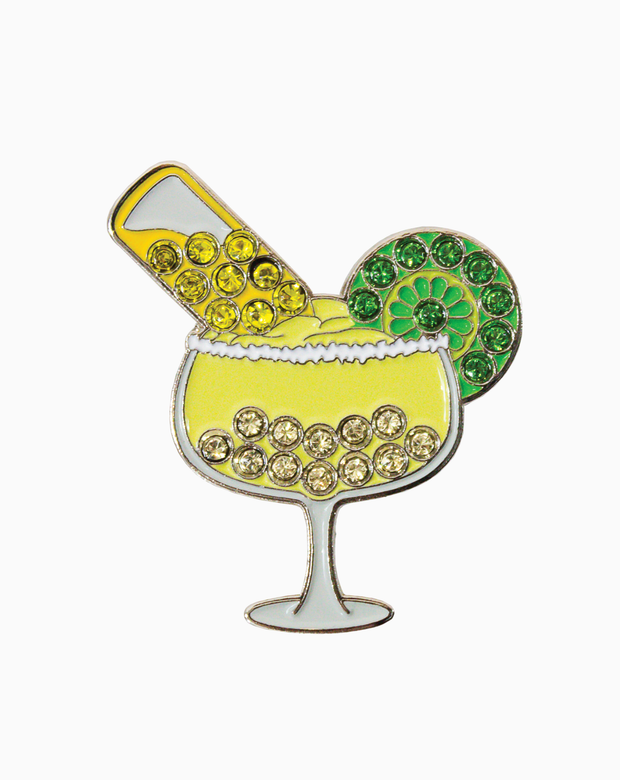 Gold and green golf ball marker shaped like a margarita glass with Swarovski crystals, photographed on a white background.