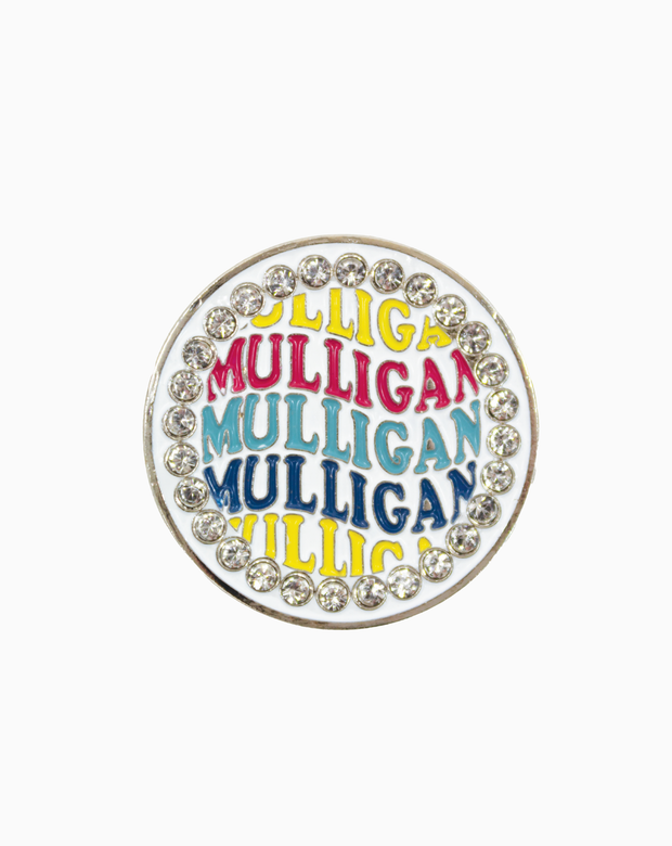 A round MXM ball marker featuring the word “Mulligan” in colorful stacked lettering, surrounded by a border of clear Swarovski crystals on a white background.